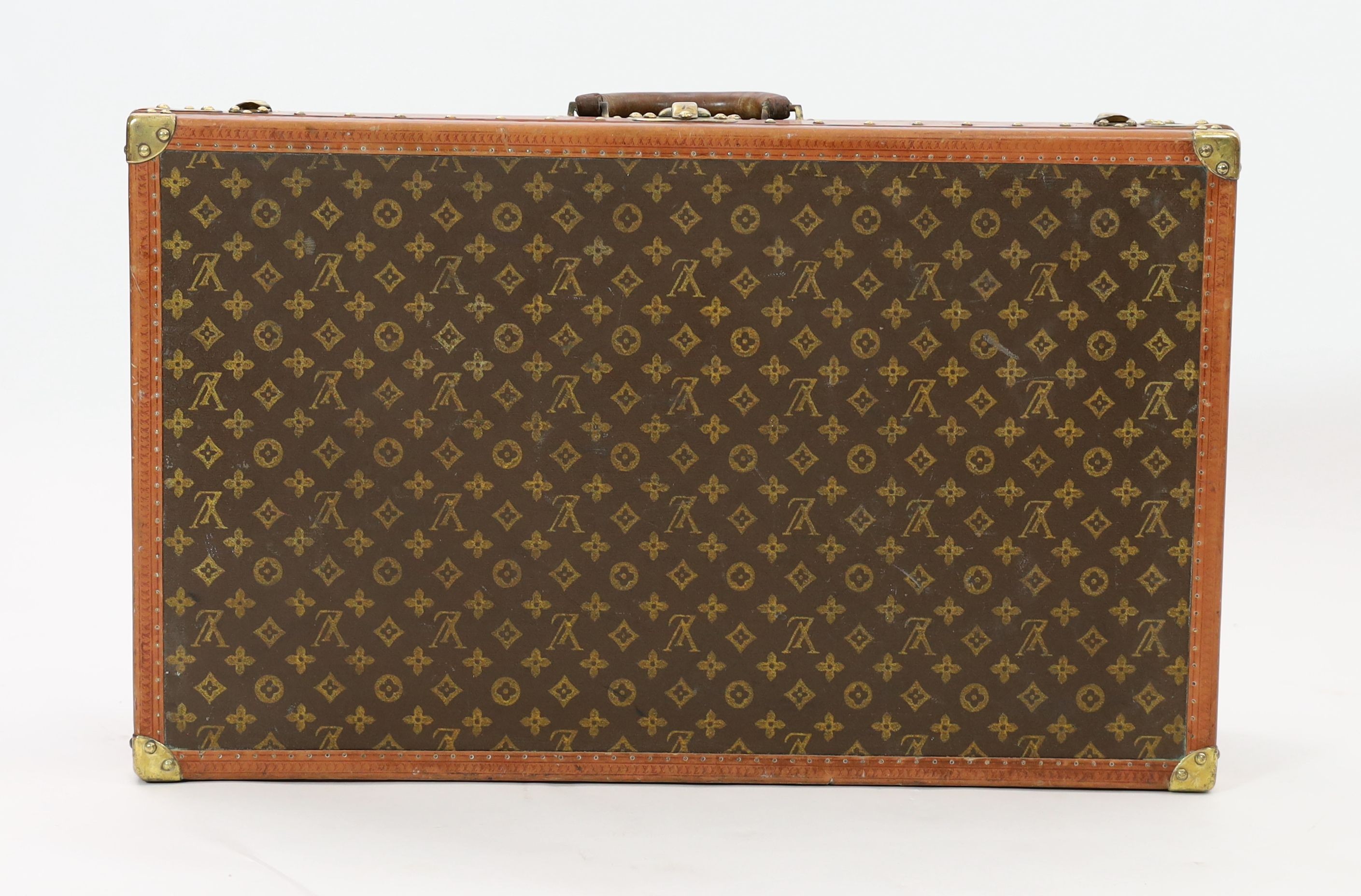 A Louis Vuitton brass mounted leather bound suitcase, 76 x 46cm depth 22cm